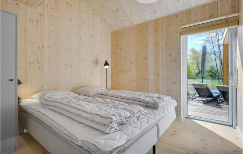 a bedroom with a bed and a sliding glass door at Beautiful Home In Sjællands Odde With 5 Bedrooms in Yderby