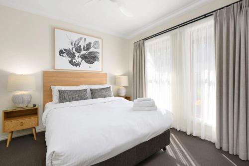 a bedroom with a large bed and a large window at Melview Greens - Two-Bedroom Apartment in Orange