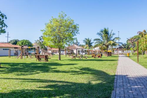 a park with a playground and swings at Refúgio Tropical Casa de Praia com Piscina Climatizada e 4 Suítes e garagem 3 carros, 800 mtrs da praia internet 700 mbps, condomínio privado com pista de skate , quadra de futevôlei , campos e quadras de futebol! in Cabo Frio