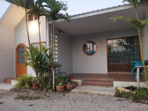 a house with palm trees in front of it at Numhom Resort in Ban Nong Chum Saeng