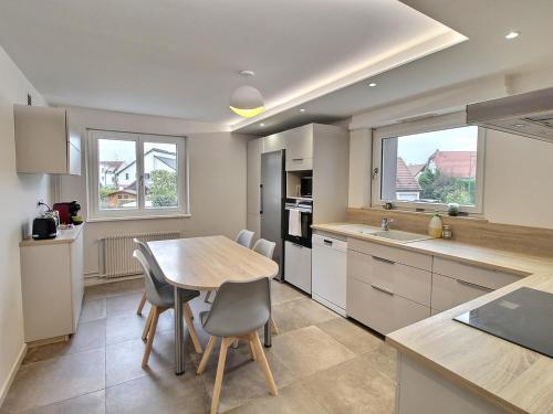 une cuisine avec une table et des chaises dans une cuisine dans l'établissement Maison spacieuse à Colmar, 5 chambres, terrasse, WiFi, parking gratuit - FR-1-722-12, à Colmar