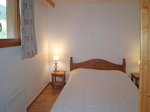 - une chambre avec un lit, une fenêtre et 2 tables dans l'établissement Appartement ski aux pieds avec piscine & sauna pour 6 pers - FR-1-322-659, aux Orres