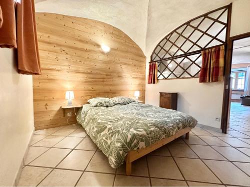- une chambre avec un lit et un mur en bois dans l'établissement Charmant 2 pièces avec Wi-Fi et parking à La Salle-les-Alpes - FR-1-762-53, à La Salle Les Alpes