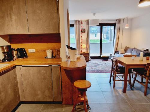 Il comprend une cuisine et une salle à manger avec une table. dans l'établissement Appartement cosy au centre station, proche pistes, parking, WiFi - FR-1-755-35, à Aime La Plagne
