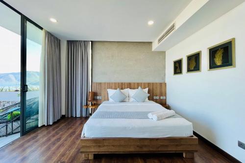 a bedroom with a bed and a large window at Anh Nguyen Oceanfront Luxury Villas Nha Trang in Nha Trang
