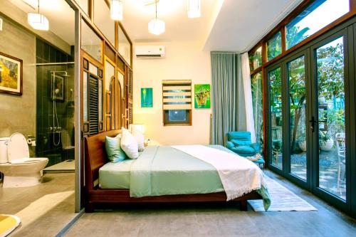 a bedroom with a bed and a bathroom with a shower at Laluka House in Hoi An