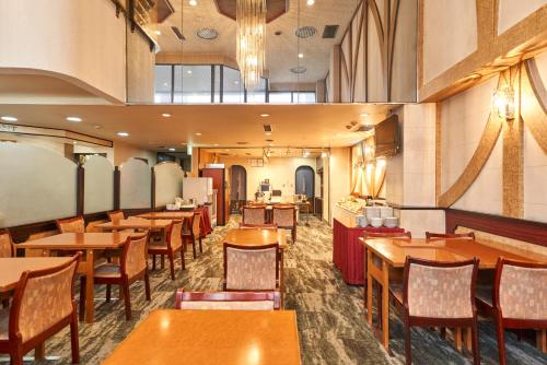 a dining room with wooden tables and chairs at Hotel Paco Obihiro Chuo in Obihiro