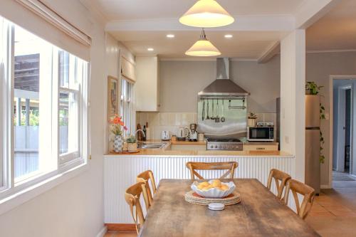 a kitchen with a table with a bowl of fruit on it at The Little White Cottage - Country Elegance Near CBD in Mudgee