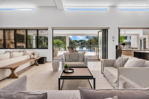 a living room with couches and a table at Villa 8 The Lakes in Yaroomba