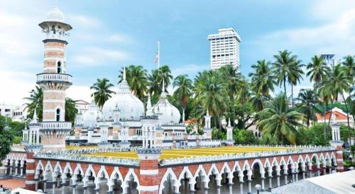 a mosque in a city with palm trees in the background at OYO 264 City Edge Hotel in Kuala Lumpur