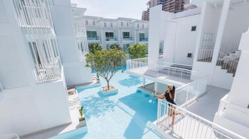a woman walking on the balcony of a building at Prima Hotel Pattaya in North Pattaya