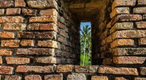 an opening in a brick wall with a window at Hotel Pangkor Mutiara in Pangkor