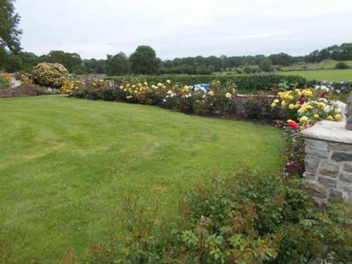 a garden with colorful flowers and a green lawn at Villa Pio Luxury Apartment in Cong