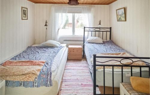 two twin beds in a room with a window at One-Bedroom Holiday Home In Unnaryd in Unnaryd
