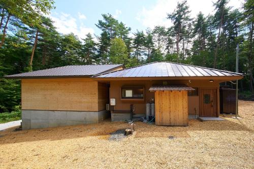 a small house with a metal roof at Azumino Komorebi - 安曇野こもれび - in Azumino