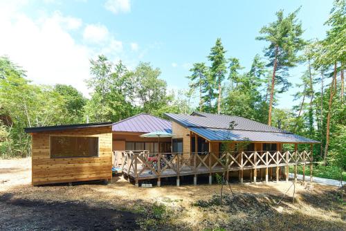 a log cabin with a porch and a roof at Azumino Komorebi - 安曇野こもれび - in Azumino