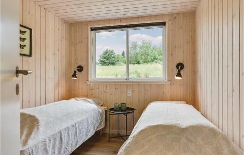 two beds in a room with a window at Holiday Home Vejby With Fireplace 05 in Vejby