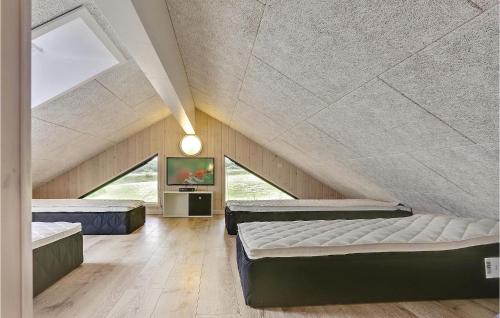 a attic bedroom with two beds and a tv at Holiday Home Vejby With Fireplace 05 in Vejby