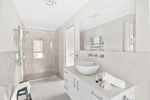 a white bathroom with a sink and a shower at Exeter House Estate Vineyard Residence in Exeter