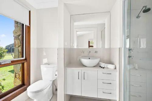 a white bathroom with a toilet and a sink at Exeter House Estate Vineyard Residence in Exeter