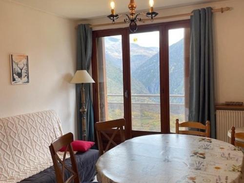 une salle à manger avec une table et une grande fenêtre dans l'établissement Appartement 3 pièces pour 6 pers, animaux admis, proche pistes - FR-1-636-234, à Orcières
