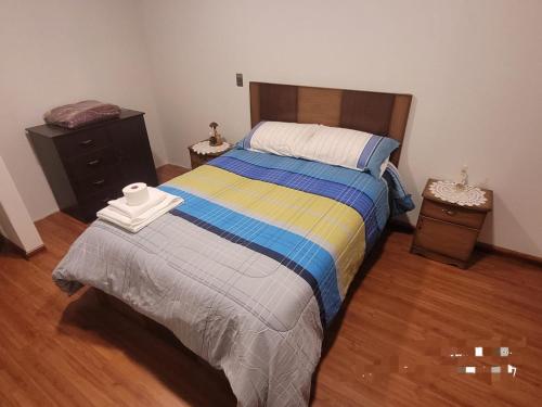 a bedroom with a bed and a wooden floor at Multifamiliar QUIROGA - PIZARRO in La Paz