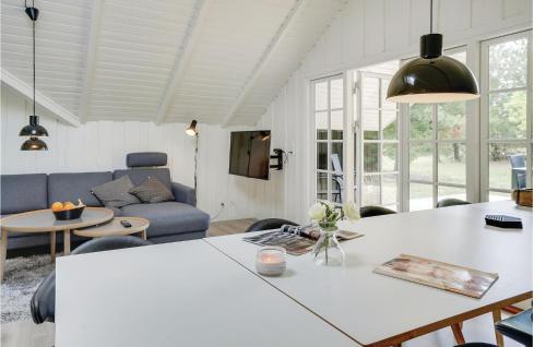 a living room with a table and a couch at Four-Bedroom Holiday Home In Blavand in Blåvand
