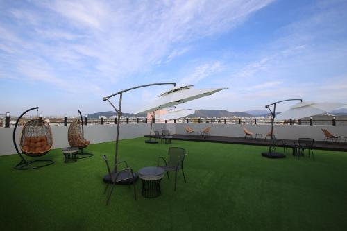 a patio with chairs and tables on a roof at Hotel rein in Gyeongju