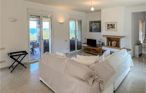 a living room with a white couch and a fireplace at Beautiful Home In Perdika With Wifi in Perdhika