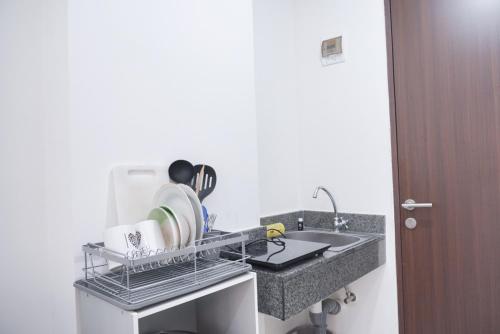 Il comprend une cuisine équipée d'un évier et d'un portant. dans l'établissement Cozy Living Studio Transpark Cibubur near Shopping Center Apartment By Travelio, à Depok