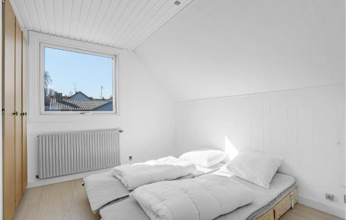a white room with a bed with pillows on it at 5 Bedroom Lovely Home In Allinge in Allinge