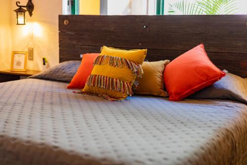 a bed with colorful pillows on top of it at Casa de hospedaje -La Abadía de San Pedro in Guadalajara