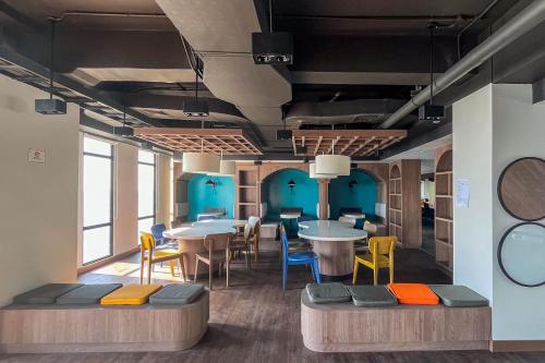 a room with tables and chairs and blue walls at Comfortable and Nice Studio Apartment at Delft Ciputra Makassar By Travelio in Sungguminasa