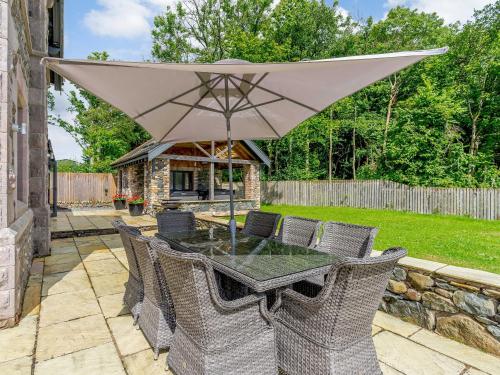 a patio with a table with an umbrella at Herdwick View - Uk33668 in Bassenthwaite Lake