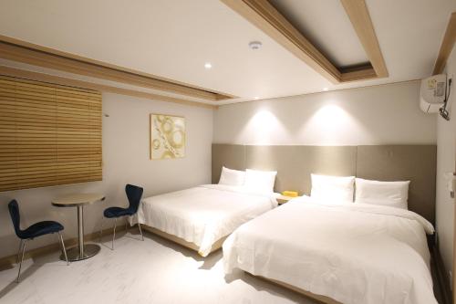 a hotel room with two beds and a table at Hotel rein in Gyeongju