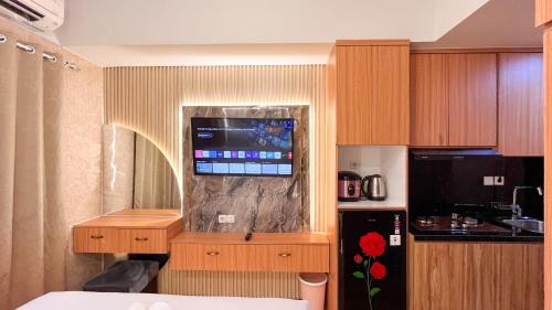 a room with a kitchen with a tv on a counter at Comfortable and Nice Studio Apartment at Delft Ciputra Makassar By Travelio in Sungguminasa