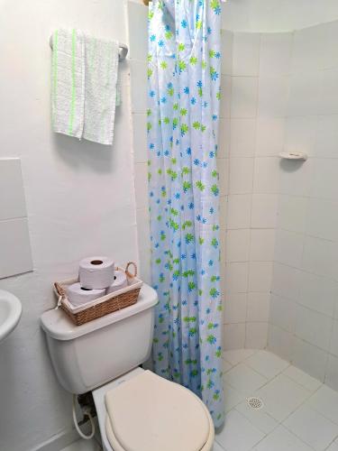 a bathroom with a toilet and a shower curtain at Casa Colinas in Buenaventura