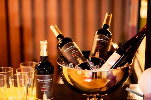 a basket of wine bottles on a table with glasses at Coco Residence, Si Saket in Khun Han