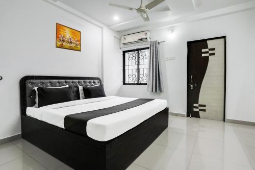 a bedroom with a black and white bed and a window at Hotel O Grand Trinity in Nagpur
