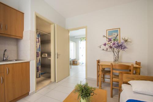 a kitchen and dining room with a table and a kitchen and a room at Erato Studios & Apartments in Kos Town