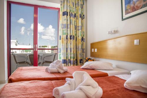 a room with two beds with towels on them at Erato Studios & Apartments in Kos Town