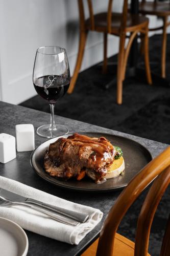 a plate of meat and a glass of wine on a table at St Francis Winery in Old Reynella