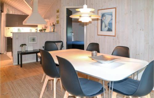 a dining room with a white table and chairs at Holiday Home Sikavej Oksbøl Vi in Mosevrå