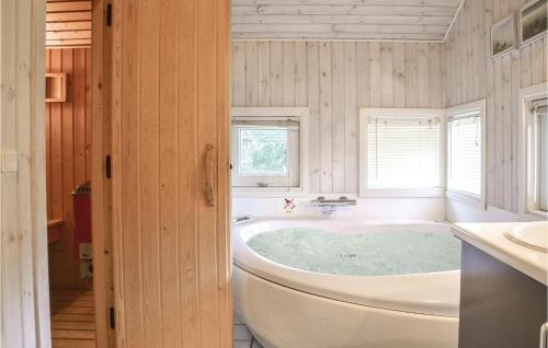 a bathroom with a tub and a sink at Holiday Home Sikavej Oksbøl Vi in Mosevrå