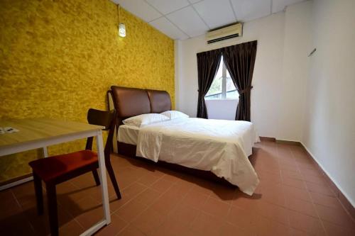 a bedroom with a bed and a table and a window at First Star Homestay in Kluang