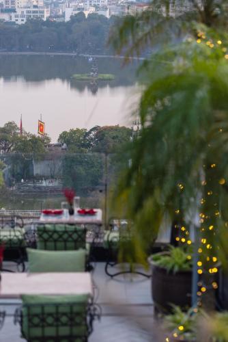 a view of a lake with a table and chairs at Hanoi Tirant Hotel in Hanoi