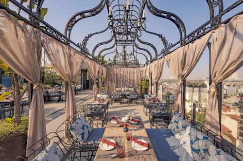 a dining room with a chandelier and a table at Hanoi Tirant Hotel in Hanoi