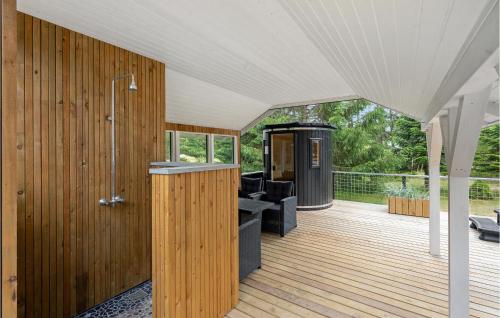a wooden deck with a shower and a bath room at Awesome Home In Blåvand With Sauna in Blåvand