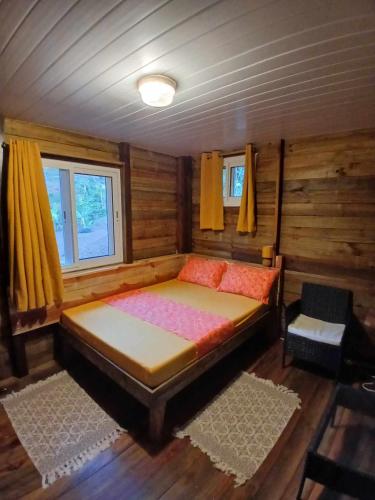a bedroom with a bed in a wooden room at Hiva oa chalets in Atuona