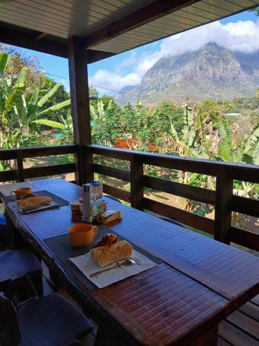 a table with food on it with a view of a mountain at Hiva oa chalets in Atuona
